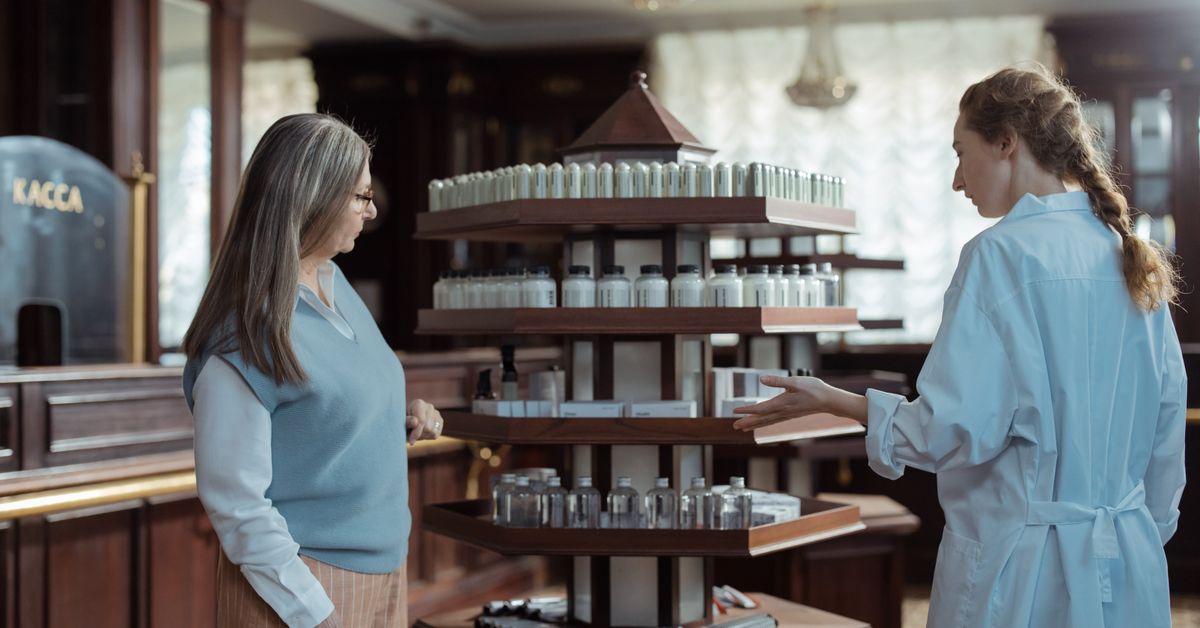 Persona atendiendo a un cliente en el mostrador de una farmacia con producto en exhibición